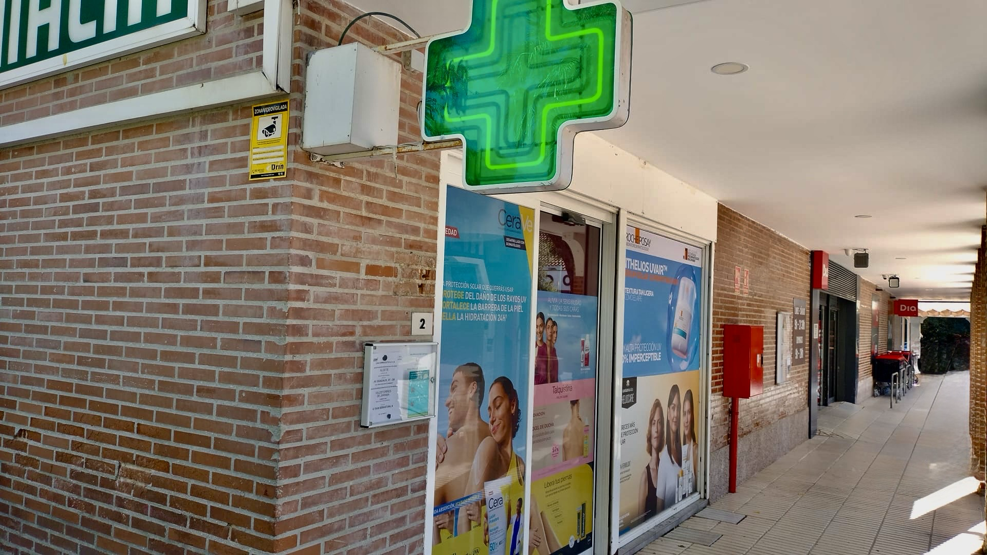 Cruz verde y entrada de la Farmacia Santo Domingo en Algete